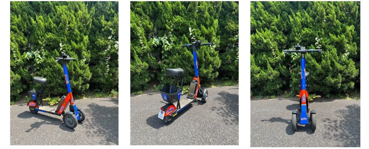 緑の生垣を背景に停まる三輪電動スクーター