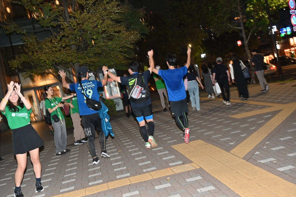 夜の街路を歩くイベント参加者たち