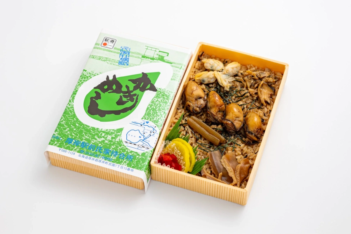 木箱に入った厚岸駅弁で、牡蠣とあさりがたっぷり乗った炊き込みご飯が特徴