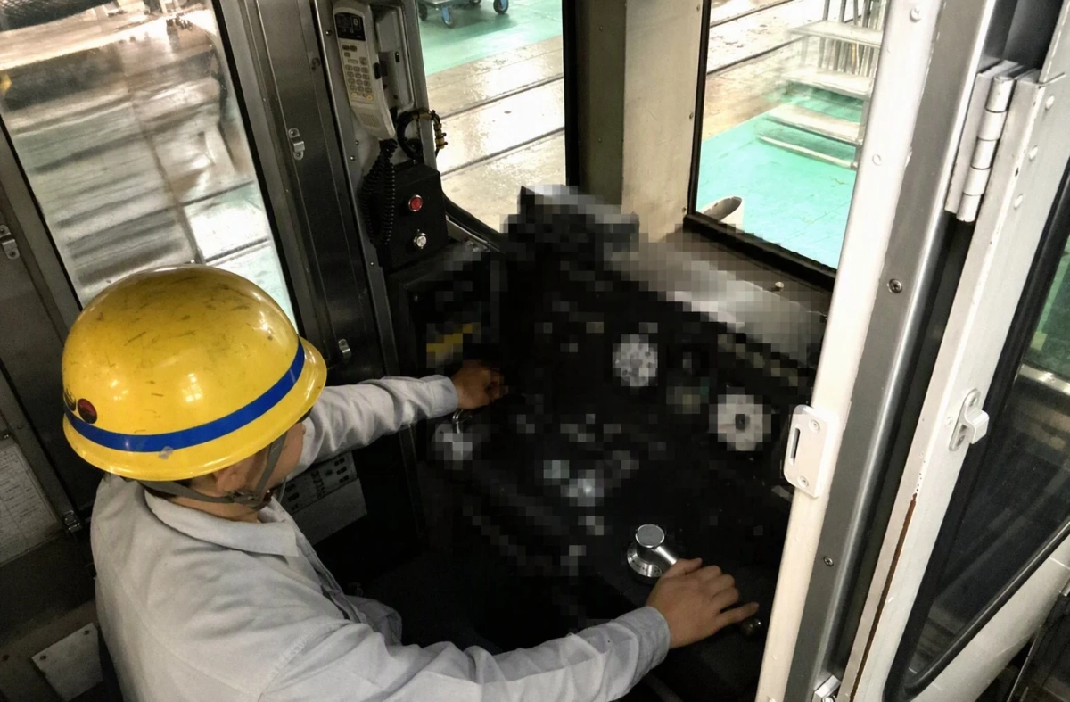 車両の運転席でレバーを操作する作業員