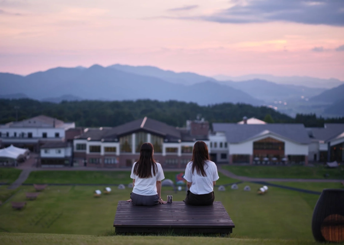 夕暮れのベンチで景色を眺める人々