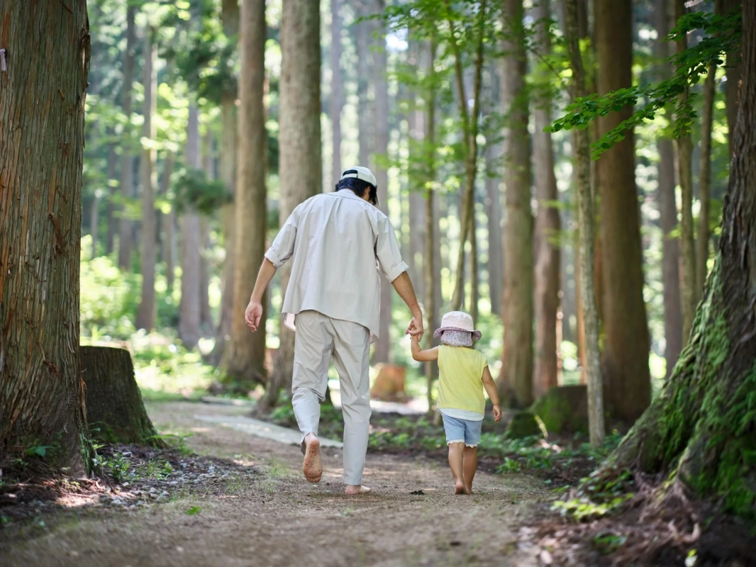 森のはだし道を歩く親子