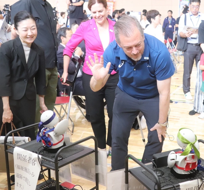 体育館でロボットと交流する人々