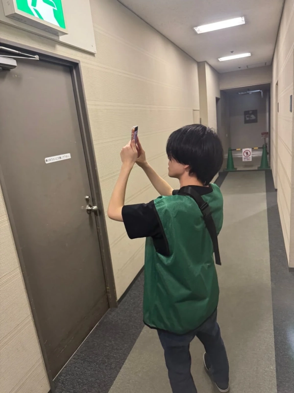 市民がスマートフォンで屋内を撮影している様子