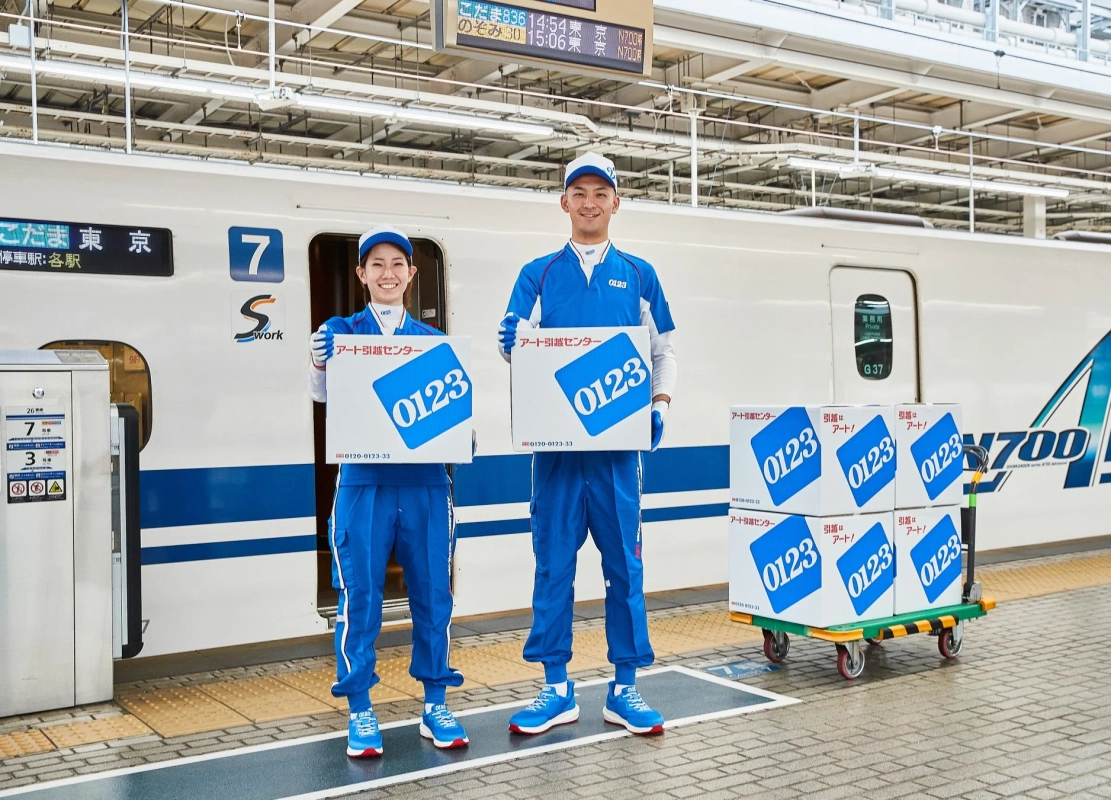 新幹線へ荷物を運び込むアート引越センターのスタッフ