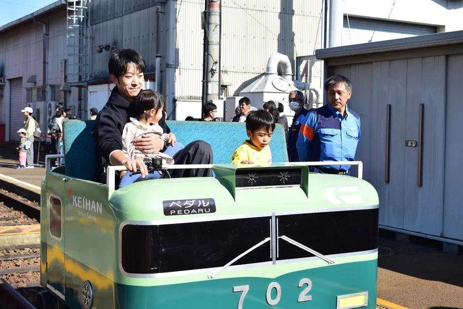 ミニ京阪電車に乗る家族
