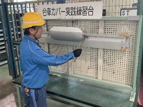 台車カバーの実践練習を行う作業員
