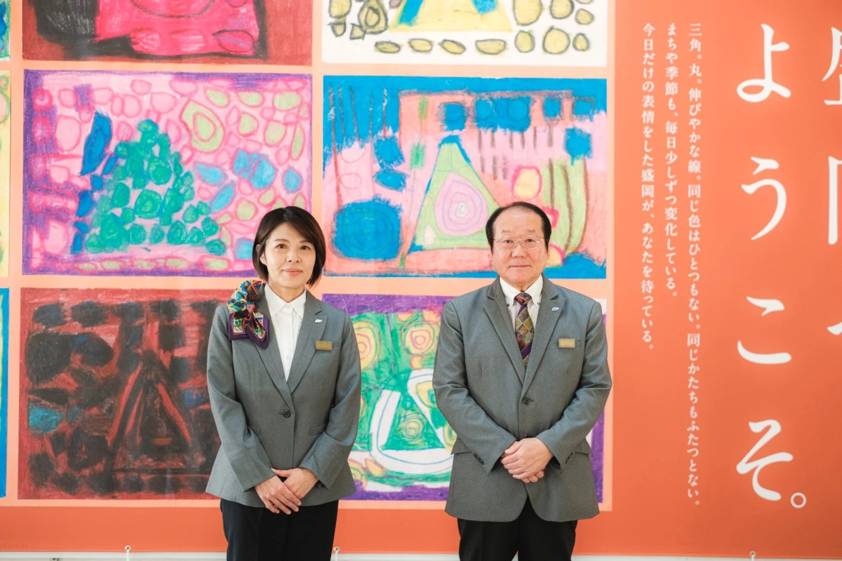 アートを背景に立つビジネススーツの男女