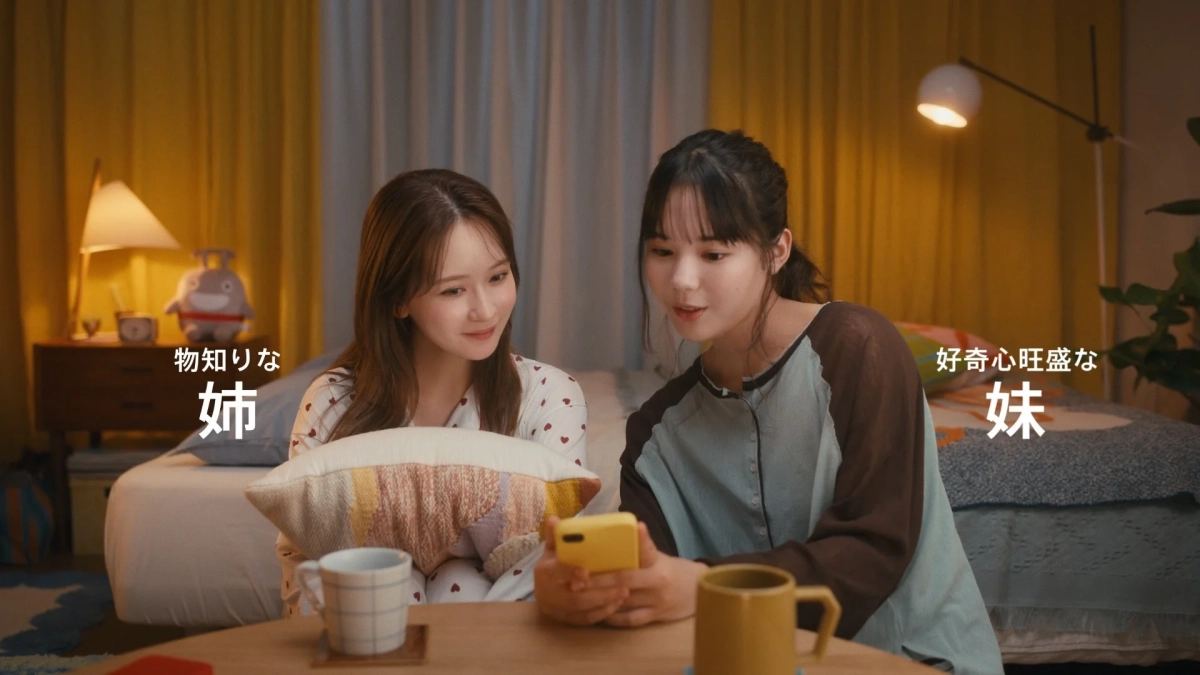 夜の部屋でスマートフォンを見ながらくつろぐ姉妹