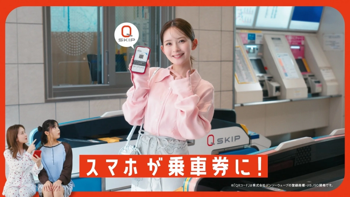 駅の改札前でスマートフォンをかざして笑顔を見せる女性たち