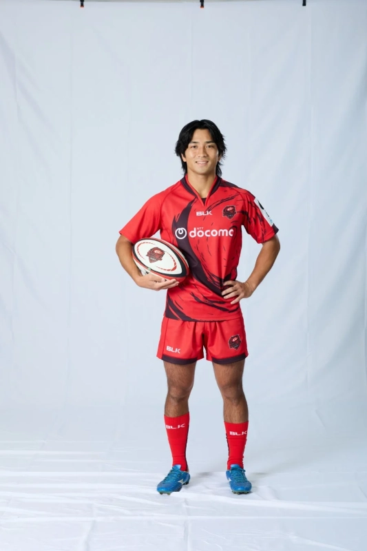 赤いユニフォーム姿でマイクを持つ山内俊央選手